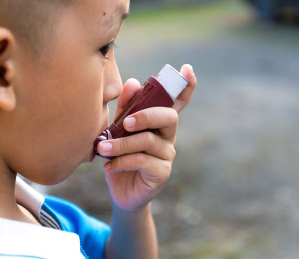 DG - a boy using an inhaler