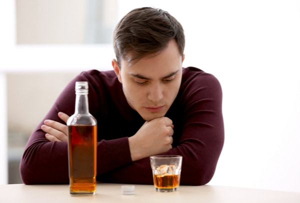 Man drinking whisky at home